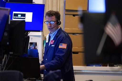 A trader works in his booth on the floor of the New York Stock Exchange. Stocks are falling sharply today as worries sweep from Wall Street to Sydney that the worsening pandemic in hotspots around the world will derail what