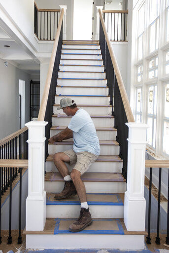 Joe Dell works on a staircase at a home in Traverse City, Mich. Home construction in the U.S. jumped 6.3% in June, another big swing in a volatile year.    PHOTO CREDIT: Mike Krebs