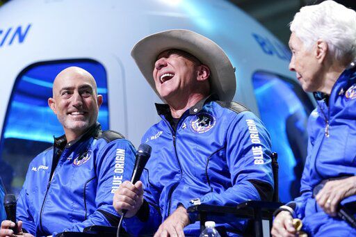 Mark Bezos, left, Jeff Bezos, center, founder of Amazon and space tourism company Blue Origin, and Wally Funk, right, make comments during a post launch news briefing from its spaceport near Van Horn, Texas, Tuesday, July 20, 2021. (AP Photo/Tony Gutierrez) PHOTO CREDIT: Tony Gutierrez