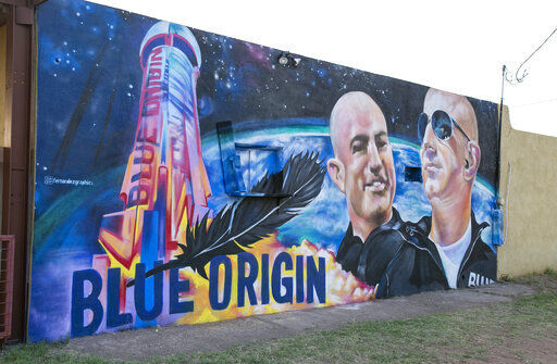 A mural by Fernandezgraphics of Blue Origin and Amazon founder Jeff Bezos is seen on the wall of a building Tuesday in Van Horn, Texas. Bezos has blasted into space on his rocket company’s first flight with passengers. He’s the second billionaire in just over a week to ride his own spacecraft. The Amazon founder rode to space with a hand-picked group and their Blue Origin capsule landed 10 minutes later on the desert floor in West Texas. (Jacob Ford/Odessa American via AP) PHOTO CREDIT: Jacob Ford