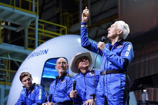 Oliver Daemen, from left, Mark Bezos and Jeff Bezos, founder of Amazon and space tourism company Blue Origin, look on as Wally Funk, right, describes the experience after their launch from the spaceport near Van Horn, Texas, Tuesday, July 20, 2021. (AP Photo/Tony Gutierrez) PHOTO CREDIT: Tony Gutierrez