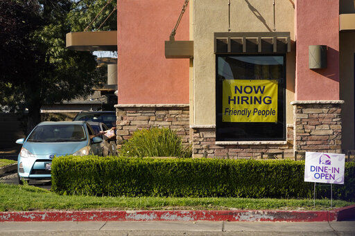 A hiring sign hangs in the window of a Taco Bell in Sacramento, Calif., Thursday, July 15, 2021. Hiring in California slowed down in June as the unemployment rate held steady at 7.7% according to new numbers released on Friday, July 16, 2021 by the Employment Development Department. California gained 73,000 jobs in June, ending the state