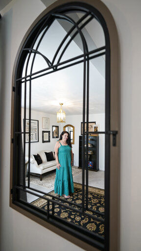 Heather Bise, owner of The House of Bise Bespoke, is reflected in a mirror in the "Art" bedroom, Monday, July 19, 2021, in Cleveland. Small businesses in the U.S. that depend on tourism and vacationers say business is bouncing back, as people re-book postponed trips and take advantage of loosening restrictions, a positive sign for the businesses that have struggled for more than a year. Bise started in 2019 and catered to international tourists, attracting guests from New Zealand, Botswana, Eastern Europe and elsewhere. (AP Photo/Tony Dejak)    PHOTO CREDIT: Tony Dejak