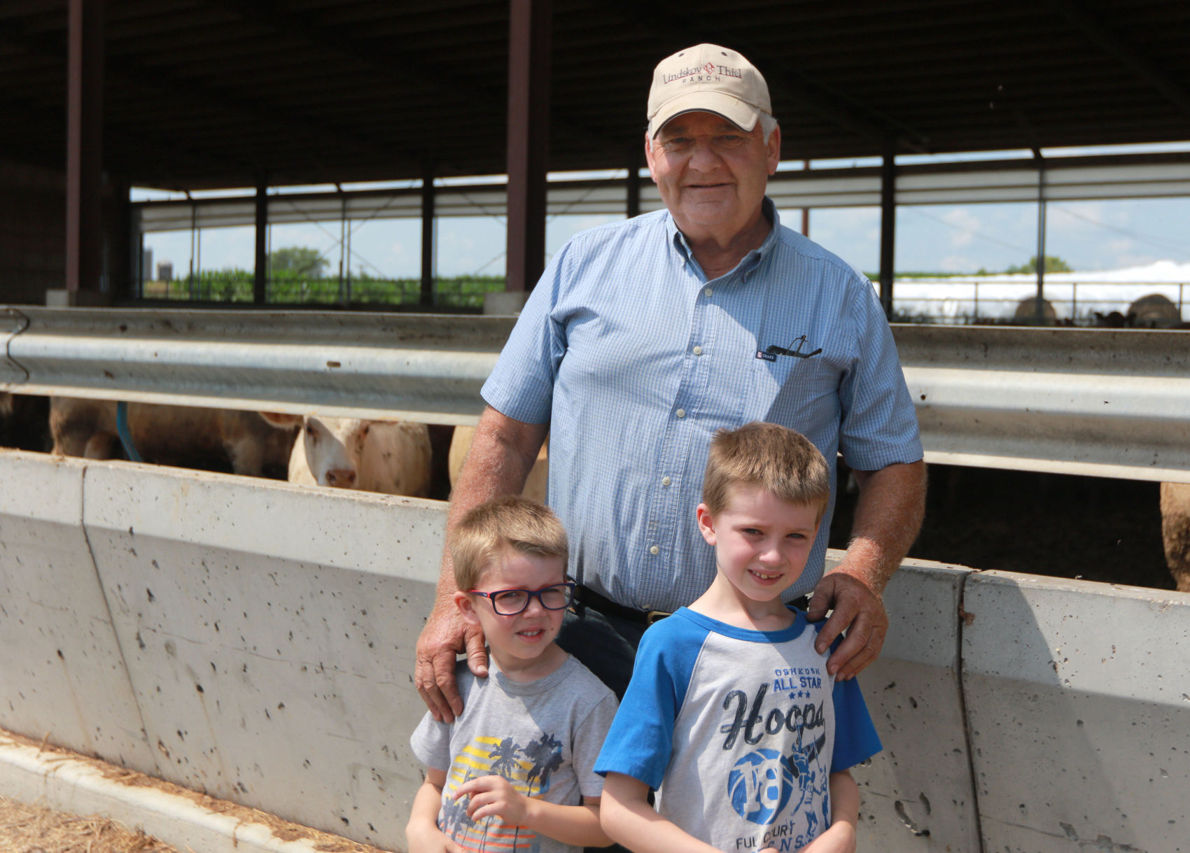 Jack Smith stands with his grandsons Ben Smith (left), 5, and Jack Smith, 7, on their family farm in Bankston, Iowa. PHOTO CREDIT: Katie Goodale