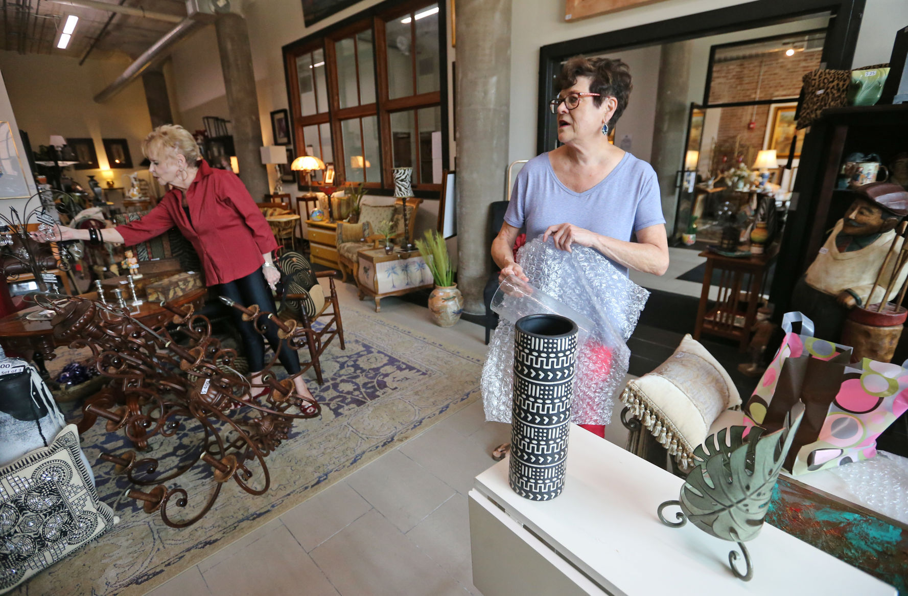 Audrey Wallis (right) talks with customer Carol Bush, of East Dubuque, Ill., at The Consignment Store in the Novelty Iron Works building in Dubuque on Friday, July 23, 2021.    PHOTO CREDIT: JESSICA REILLY