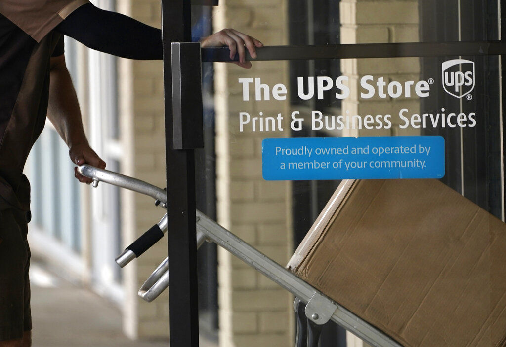 A UPS driver enters a United Parcel Service store with packages in Jackson, Miss. UPS’ second-quarter results topped Wall Street’s view as the company continues to benefit from people increasingly having more and more products delivered to their homes.    PHOTO CREDIT: Rogelio V. Solis