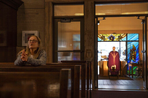 FILE - Fran DiBiasio sits alone in Our Lady of Grace Catholic Church as Rev. Peter Gower celebrates Mass from the front door as worshippers listen over the radio from their cars in the parking lot, Sunday, March 29, 2020, in Johnston, R.I. For the first time in nearly two decades, only half of U.S. households donated to a charity, according to a study released Tuesday, July 27, 2021. Experts say many factors are contributing to the decline. The percentage of Americans who give to religious causes has decreased in tandem with attendance at worship services as the number of Americans not affiliated with any religion grows. (AP Photo/David Goldman, File)    PHOTO CREDIT: David Goldman