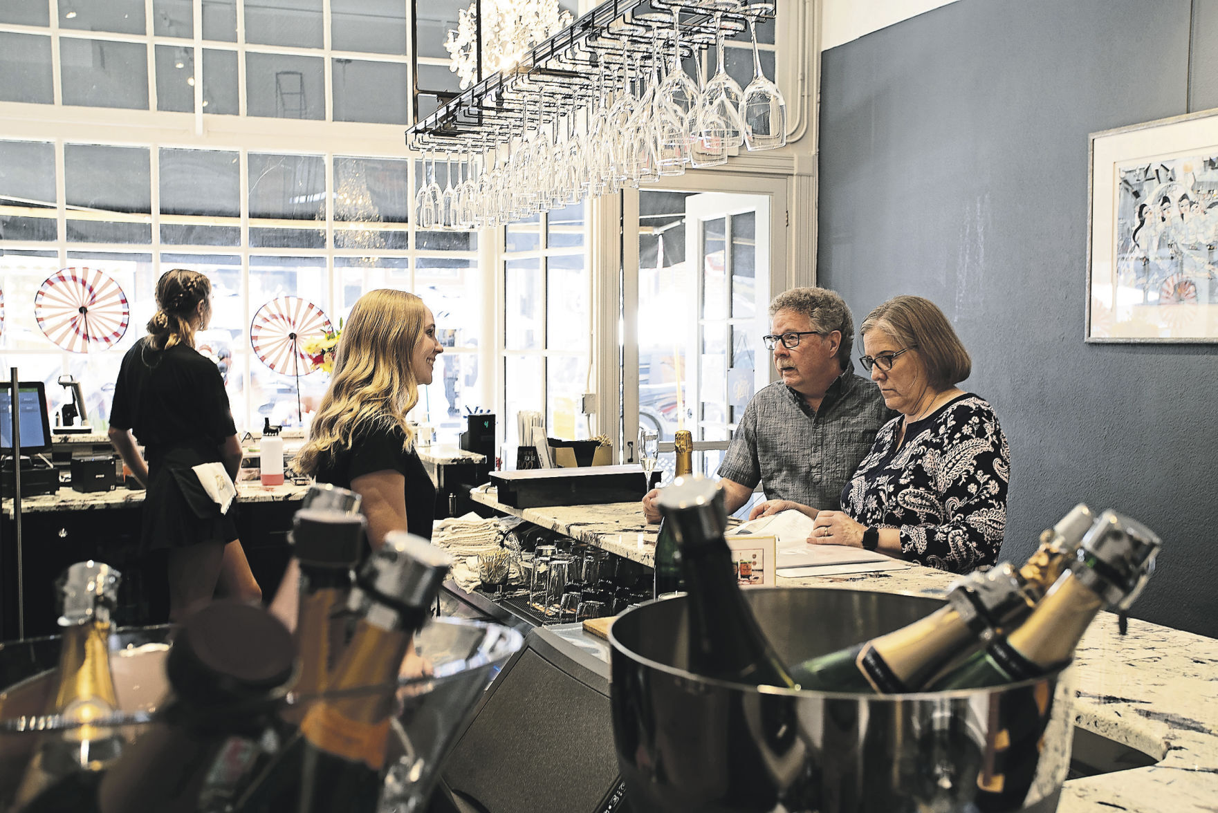 Lilly Streich takes an order from Jim and Lynda Streich at Champagne on Main.    PHOTO CREDIT: SYSTEM