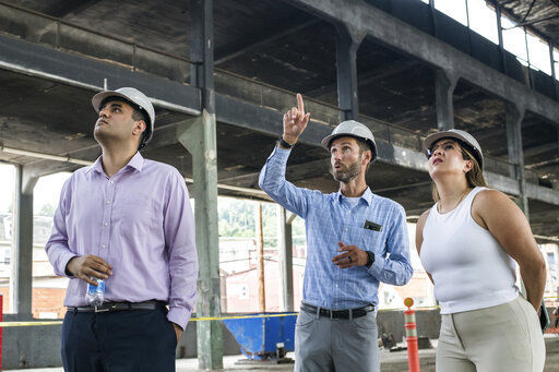 From left, AM Group co-workers Amaan Chaudry, of New York, Matthew Cypher, of Arlington, Va., and Mariana Rios, of New York, look at the space at 51 Bridge Street during a celebration marking the start of renovations to turn the former steel pipe manufacturing building to a 88,600 square-foot tech flex facility, Thursday, July 15, 2021, in Etna, Pa. The facility is geared to become a hub for a small number of companies focused on tech, robotics, and AI. (Stephanie Strasburg/Pittsburgh Post-Gazette via AP)    PHOTO CREDIT: Stephanie Strasburg