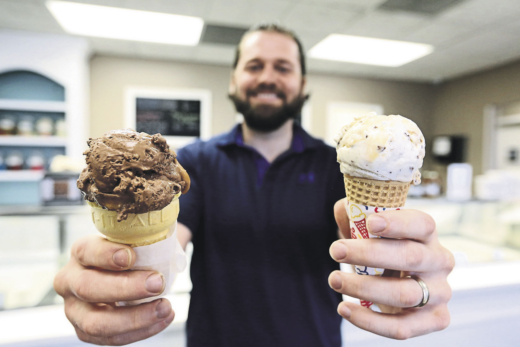 Drew Siegert, president of Betty Jane Candies in Dubuque, holds a cake cone with Gremlin ice cream (left) and sugar cone with Gremlin-Nilla ice cream.    PHOTO CREDIT: Jessica Reilly