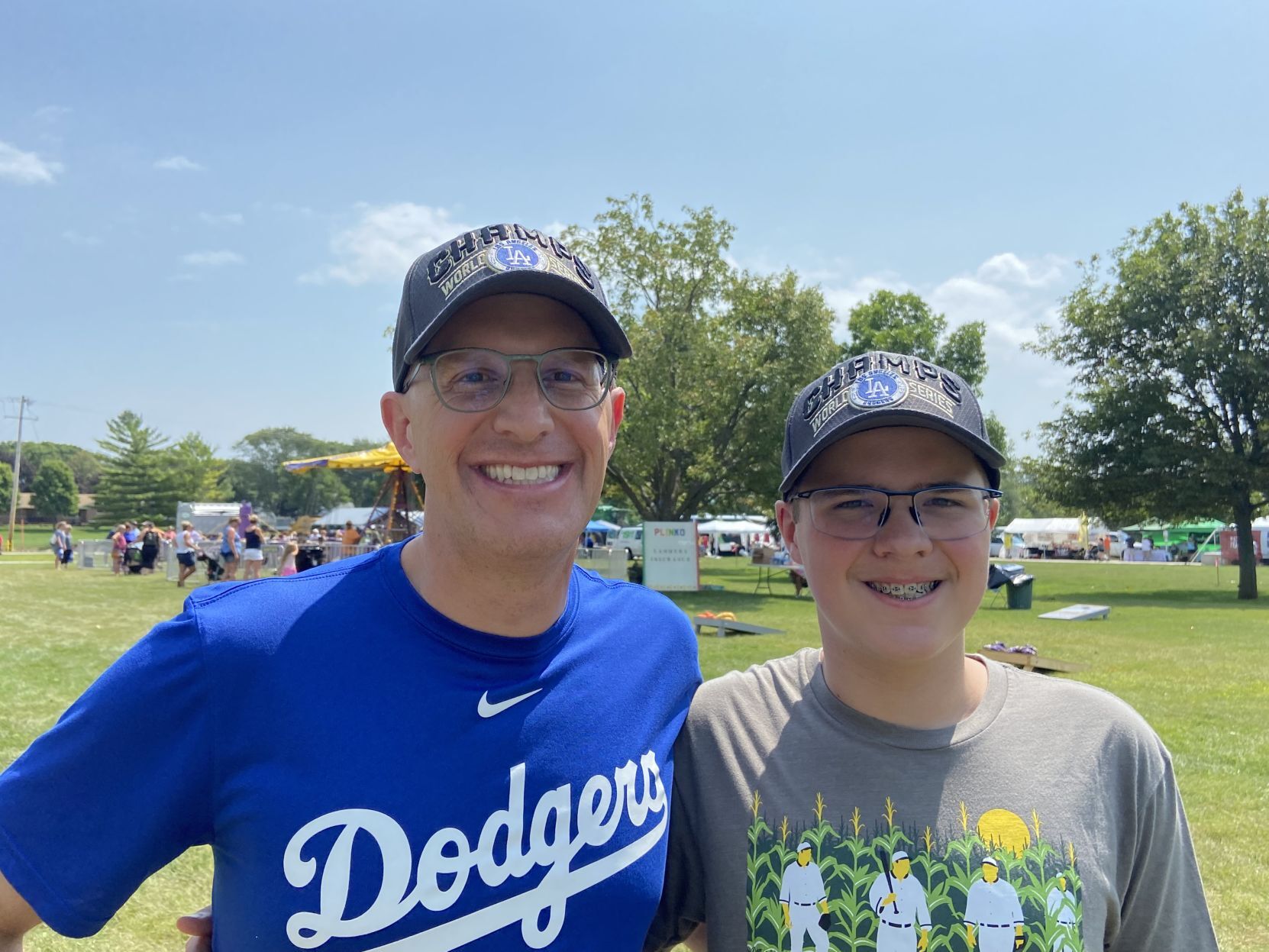 Jeff (left) and Jackson Lampe, who recently moved to Dubuque, attend Beyond the Game festivities on Wednesday in Dyersville, Iowa. 