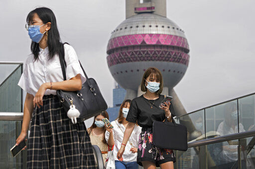 Women wearing face masks to help curb the spread of the coronavirus walk on a pedestrian overhead bridge in front of the Oriental Pearl TV Tower at the Pudong Financial District in Shanghai, China, Wednesday, Aug. 25, 2021. (AP Photo/Andy Wong)    PHOTO CREDIT: Andy Wong