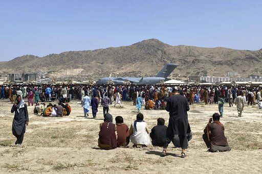 FILE - In this Aug. 16, 2021, file photo hundreds of people gather near a U.S. Air Force C-17 transport plane along the perimeter at the international airport in Kabul, Afghanistan. After the Taliban takeover, employees of the collapsed government, civil society activists and women are among the at-risk Afghans who have gone into hiding or are staying off the streets. They hope for a way to leave their homeland. (AP Photo/Shekib Rahmani, File)    PHOTO CREDIT: Shekib Rahmani