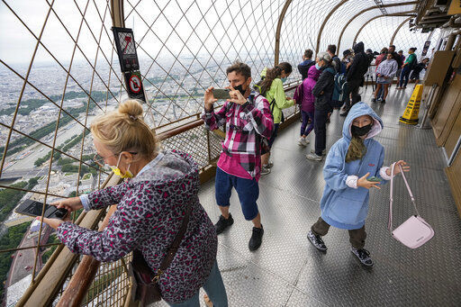 Visitors enjoy the view from top of the Eiffel Tower in Paris. The European Union is expected to recommend that its member states reinstate restrictions on tourists from the U.S. because of rising coronavirus infection levels in the country, EU diplomats said today.    PHOTO CREDIT: Michel Euler
