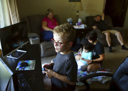 Thomas Satterfield, 8, plays Minecraft as his family hangs out at their home in Kokomo, Ind. Video games are made for entertainment, of course, but they give parents opportunities to talk about saving and spending. Some financial literacy experts actually use video games to teach kids about money. Video game currency costs real money, and you can give your kids real chores to earn it. And the games themselves offer chances for kids to explore how businesses are run and how to budget so they don’t run out of that hard-earned currency right away.     PHOTO CREDIT: Kelly Lafferty Gerber