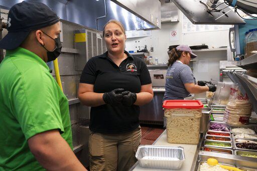 Sarah White (center) area manager of Lost Dog Cafe, trains manager Alex Aleman (left) in a new pasta preparation technique, as they work at the cafe in Fairfax, Va. Lost Dog is one of a growing number of companies that, in a desperation for hired hands, is loosening restrictions on everything from age to level of experience.     PHOTO CREDIT: Jacquelyn Martin