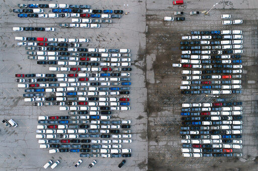 In this March 24, 2021 file photo, mid-sized pickup trucks and full-size vans are seen in a parking lot outside a General Motors assembly plant where they are produced in Wentzville, Mo. The global shortage of computer chips is getting worse, forcing automakers to temporarily close factories including those that build popular pickup trucks. General Motors announced Thursday, Sept, 2, 2021 that it would pause production at seven North American plants during the next two weeks, including two that make the company’s top-selling Chevrolet Silverado pickup.    PHOTO CREDIT: Jeff Roberson