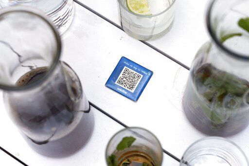 Drinks surround a barcode attached to the table at Bartaco, that patrons use to order and pay at the restaurant in Arlington, Va., on Thursday, Sept. 2, 2021. The restaurant uses an automated app for ordering and payments. Instead of servers Bartaco uses "food runners" to bring the orders to the tables. (AP Photo/Jacquelyn Martin)    PHOTO CREDIT: Jacquelyn Martin