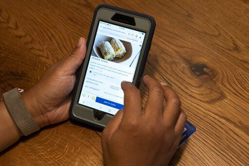 A diner at Bartaco uses their app to order an item off the menu, at the restaurant in Arlington, Va., on Thursday, Sept. 2, 2021. The restaurant is using an automated app for ordering and payments. Instead of servers they use "food runners" to get the food to the tables. (AP Photo/Jacquelyn Martin)    PHOTO CREDIT: Jacquelyn Martin