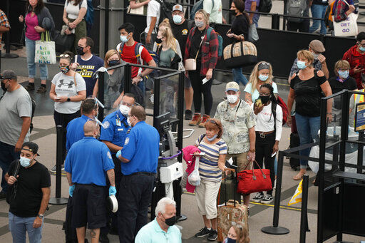 Travelers wear face coverings in the line for the south north security checkpoint in the main terminal of Denver International Airport. The worst terror attack on American soil led to increased and sometimes tension-filled security measures in airports across the world.    PHOTO CREDIT: David Zalubowski