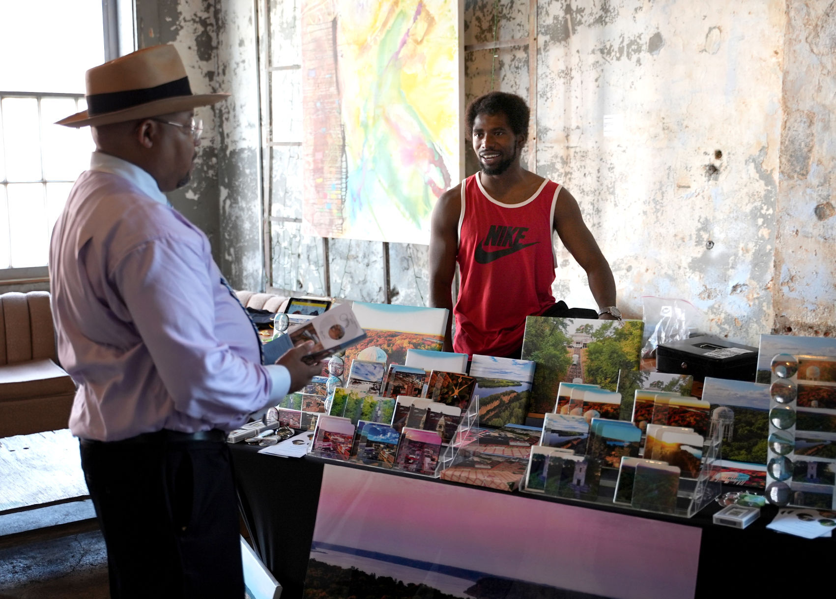 Jamal Munfard (left), of Dubuque, talks with Michael Williams, of Elevated Images Dubuque.    PHOTO CREDIT: PAUL KURUTSIDES
