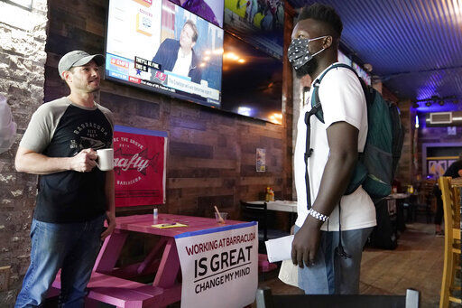 Sudy Gervais, right, talks with Lee Kessler, the owner of the Barracuda Taphouse & Grill, left, about a potential job at a job fair featuring local businesses in the Coconut Grove neighborhood of Miami, Wednesday, Sept. 8, 2021. U.S. economic activity “downshifted” in July and August due to rising concerns about COVID