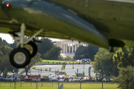 The Jefferson Memorial is visible behind White flags near the Washington Monument on the National Mall as Marine One with President Joe Biden abroad lands at the White House in Washington, Monday, Sept. 20, 2021, after returning from Rehoboth Beach, Del. The flags, which number more than 630,000, are part of artist Suzanne Brennan Firstenberg