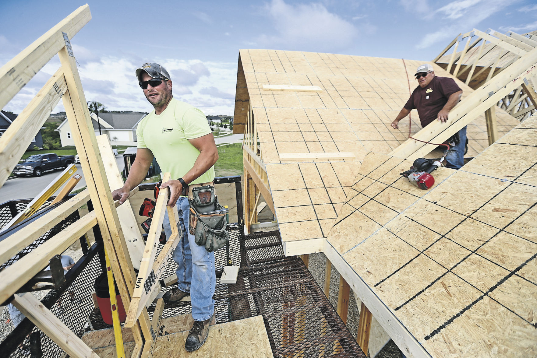 Brian Conrad (left) and Rob Conrad work on a home along Creek Wood Drive in Dubuque.    PHOTO CREDIT: JESSICA REILLY