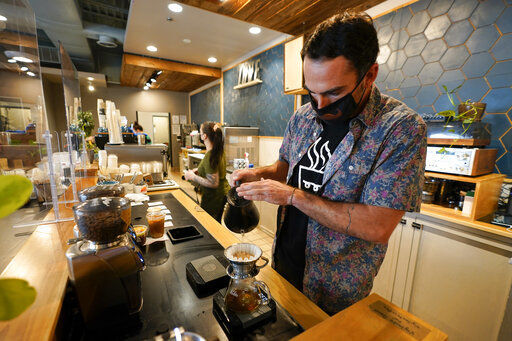 Chris Vigilante makes a dripped coffee for a customer at one of his coffee shops in College Park, Md. A confluence of supply chain problems, drought, frost and inflation all point to the price of your cup of morning coffee going up.    PHOTO CREDIT: Julio Cortez