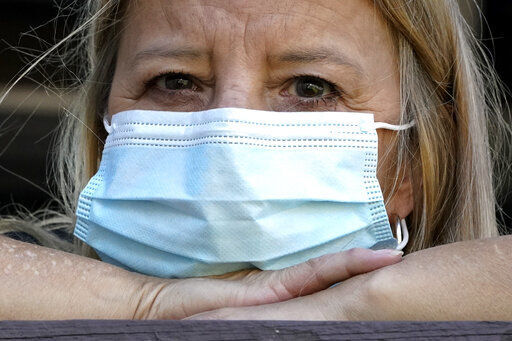 Bronwyn Russell, of Des Plaines, Ill., who has had the COVID-19 vaccine, wears a mask anytime she leaves her Illinois home. “I’m worried. I don’t want to get sick,” Russell said. Vaccinated older adults are far more worried about the virus than the unvaccinated and far likelier to take precautions despite the protection afforded by their shots, according to a new poll out today.    PHOTO CREDIT: Nam Y. Huh