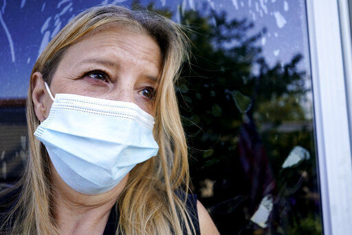 In this Monday, Sept. 27, 2021, photo Bronwyn Russell poses for a photo at her home in Des Plaines, Ill. Russell, who has had the COVID-19 vaccine, wears a mask anytime she leaves her Illinois home. “I’m worried. I don’t want to get sick,” says Russell. (AP Photo/Nam Y. Huh)    PHOTO CREDIT: Nam Y. Huh