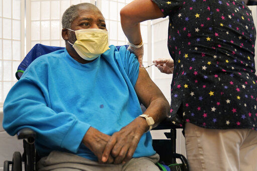 FILE - In this Sept. 27, 2021, file photo, Edward Williams, 62, a resident at the Hebrew Home at Riverdale, receives a COVID-19 booster shot in New York. The number of COVID-19 vaccinations is falling in the U.S. And some experts worry that the decision to give booster doses could end up hurting efforts to get the unvaccinated to take shots at all. (AP Photo/Seth Wenig)    PHOTO CREDIT: Seth Wenig