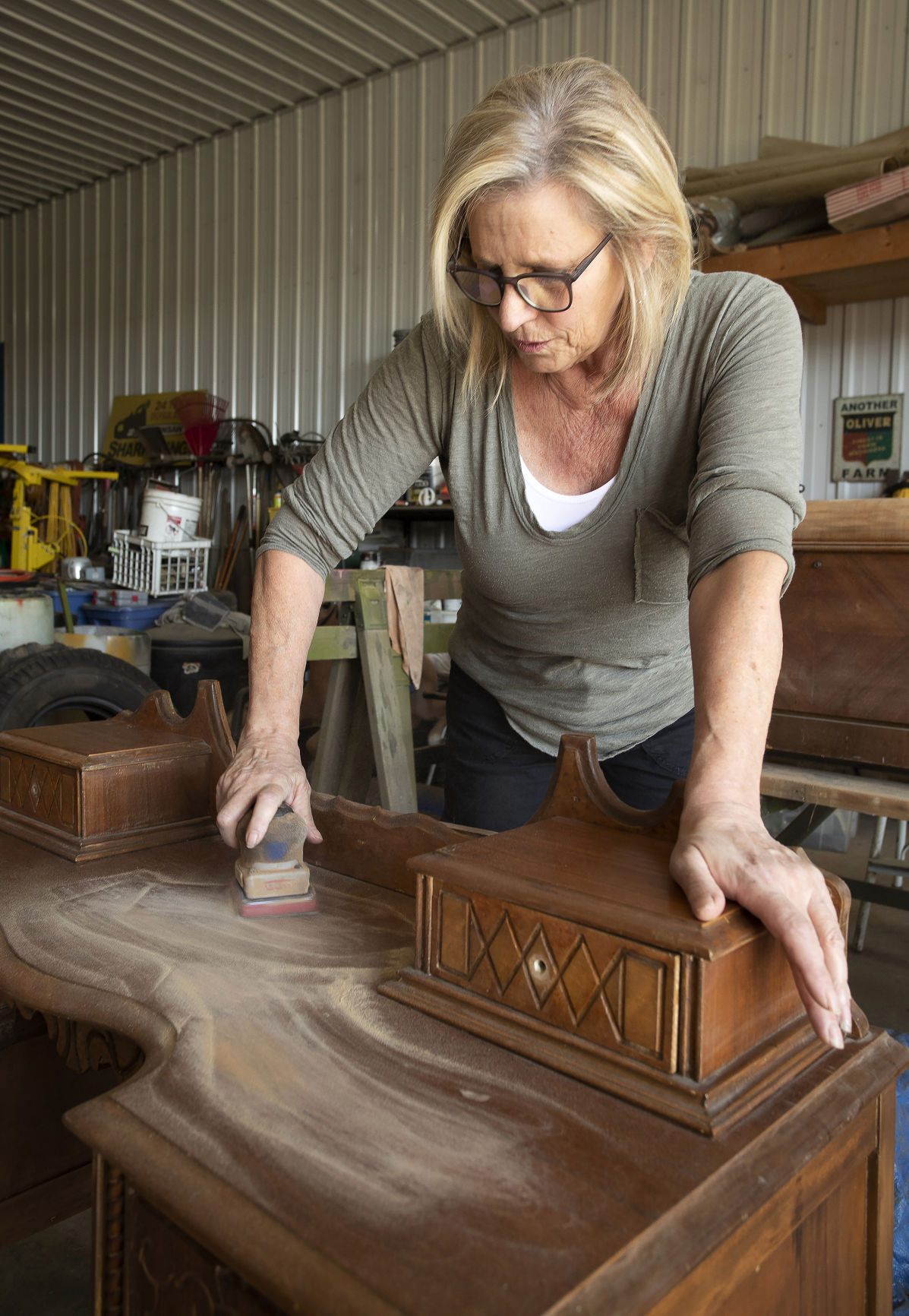 Dana Boltax sands a piece of furniture in her shop, located near Stitzer, Wis. Her business, Boltax Design Studio, creates a new look for furniture items.    PHOTO CREDIT: Stephen Gassman