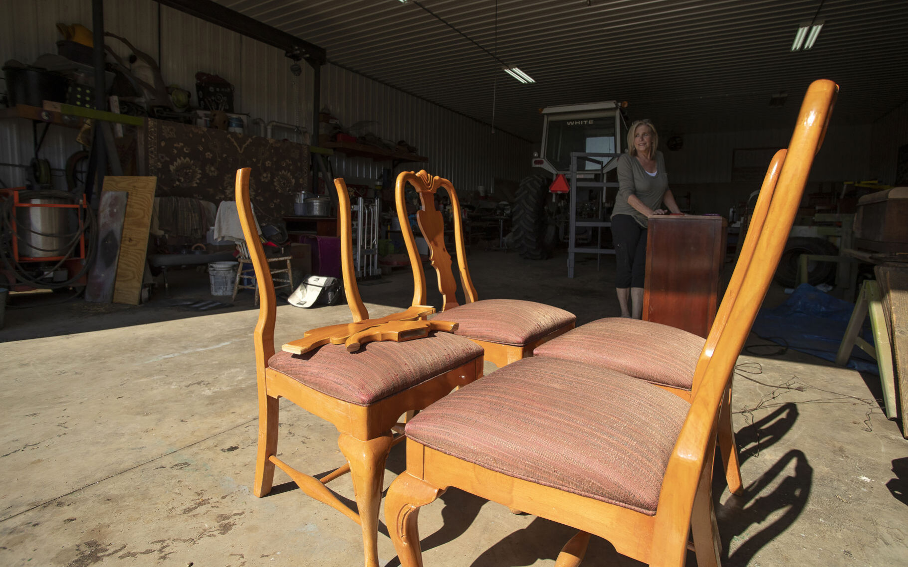 Four chairs await her attention as Dana Boltax works on a piece of furniture in her shop.    PHOTO CREDIT: Stephen Gassman