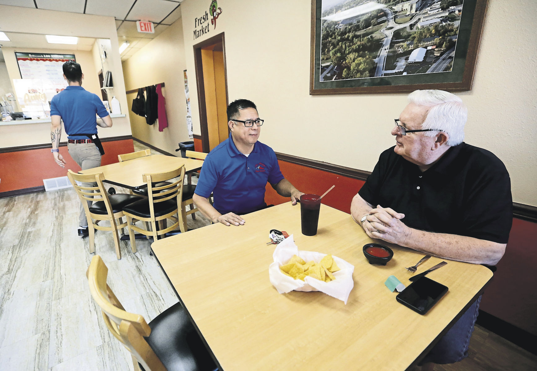 Owner Carlos Vasquez (left) talks with Jack Luedtke, of Dubuque, at Los Amigos in Platteville, Wis. Hispanic-owned establishments have provided positive economic and cultural influences in communities throughout the tri-state area.    PHOTO CREDIT: JESSICA REILLY