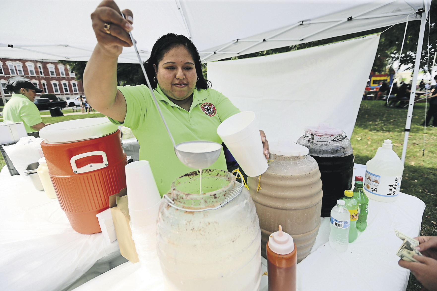 Yessica Flores, with 3 Marias Ice Cream in Platteville, Wis., serves horchata during Dubuque Latinx Fiesta.    PHOTO CREDIT: JESSICA REILLY
