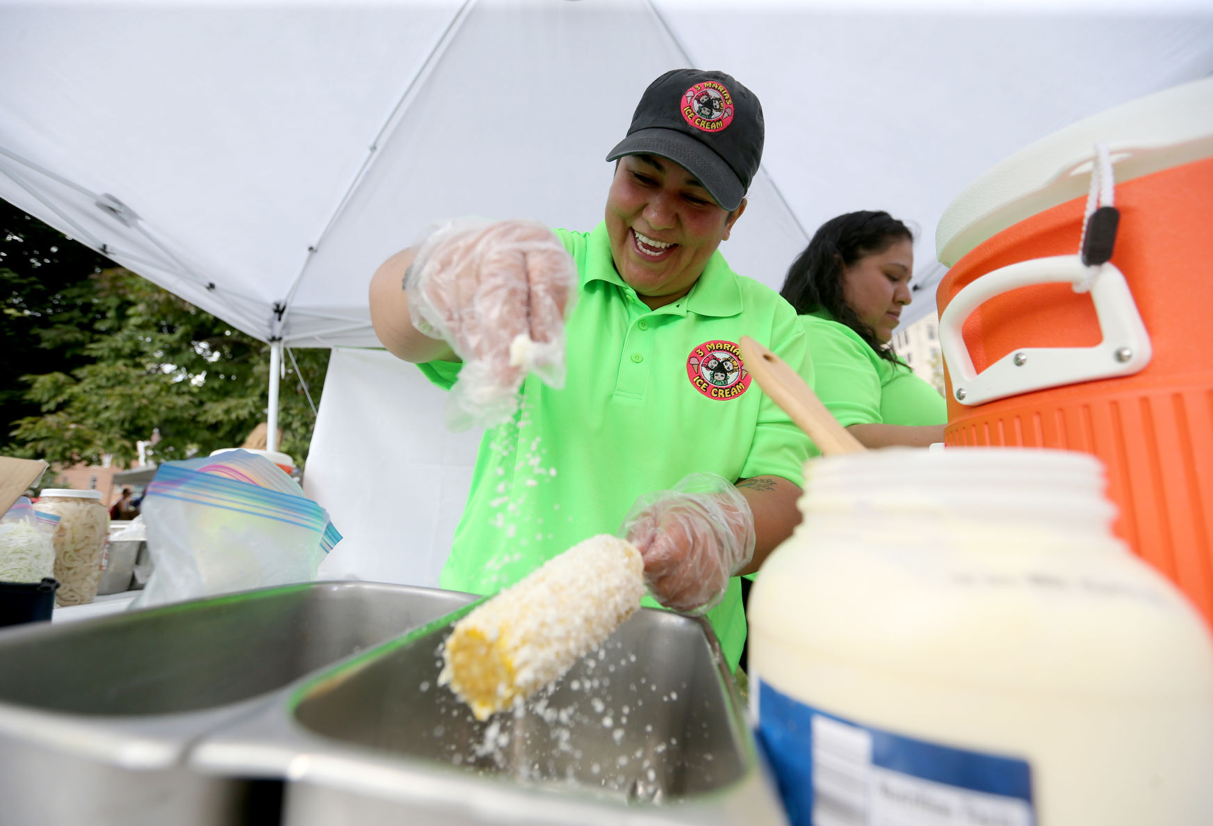 Lizbeth Moreno, with 3 Marias Ice Cream in Platteville, Wis., makes elote during the recent Dubuque Latinx Fiesta.    PHOTO CREDIT: BY GARY DURA
gary.dura@thmedia.com