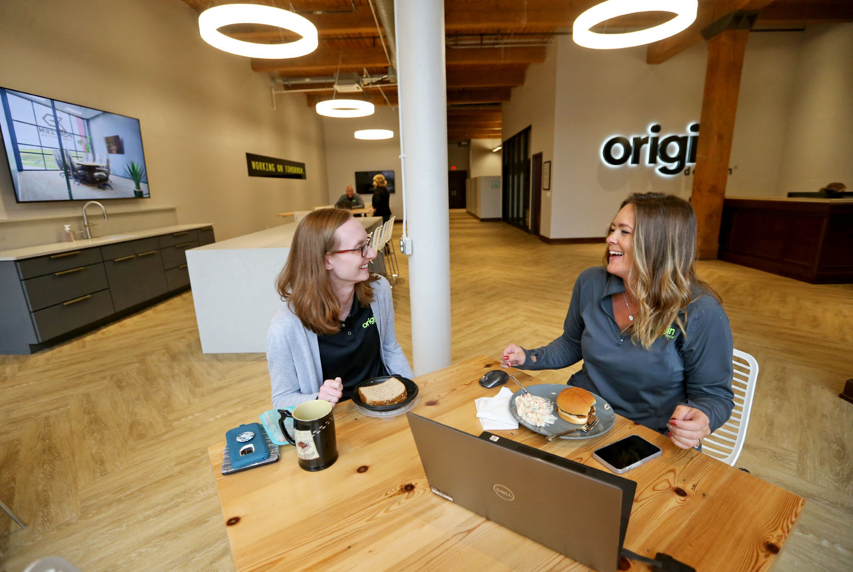 Emily Crowe (left) and Lauren Ray talk during their lunch break at Origin Design in Dubuque on Thursday.    PHOTO CREDIT: JESSICA REILLY