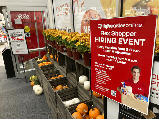In this Thursday, Oct. 7, 2021, photograph, a sign advertising for workers stands outside a Hy-Vee grocery store in Sioux Falls, S.D. Companies that typically hire thousands of seasonal workers are heading into the holidays during one of the tightest job markets in decades, making it unlikely they’ll find all the workers they need. For shoppers, it might mean a less than jolly holiday shopping experience, with bare store shelves and online orders that take longer than usual to fill. (AP Photo/David Zalubowski)    PHOTO CREDIT: David Zalubowski