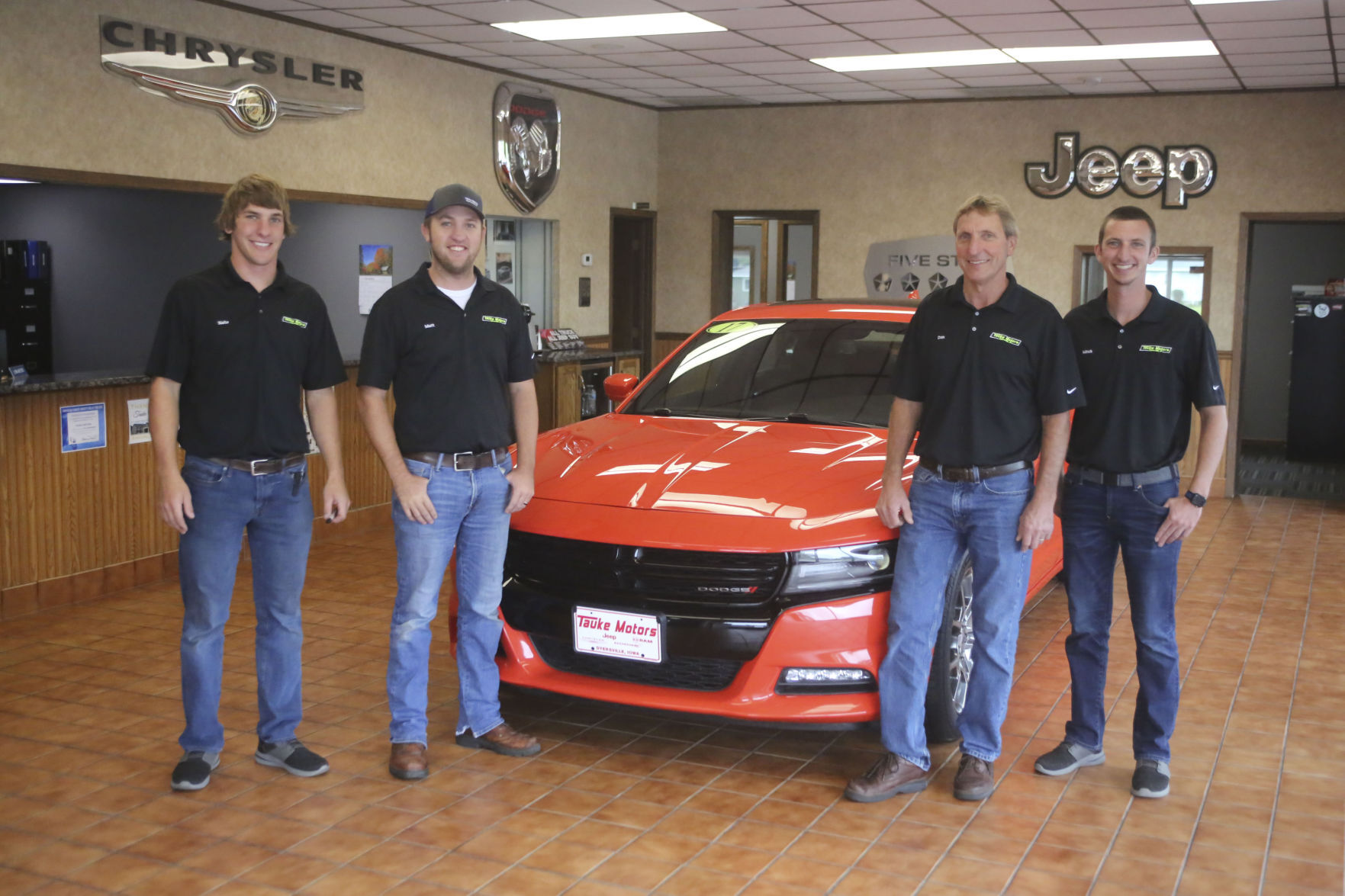 Nate (from left), Matt, Dan and Mitch Tauke enjoy a moment together in the Tauke Motors showroom in Dyersville, Iowa.    PHOTO CREDIT: Don Zieser, Dyersville Commercial