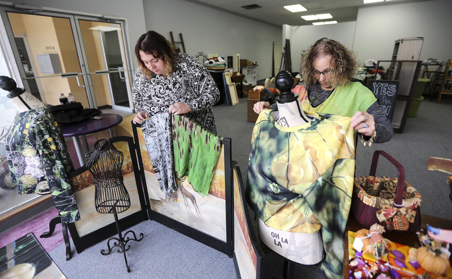 Mercantile on Main co-owners Alice Klinkhammer (left) and her mother, Vickie Klinkhammer, work on setting up a window display in their new location on Main Street in Dubuque. The two plan to open their store in November.    PHOTO CREDIT: Dave Kettering