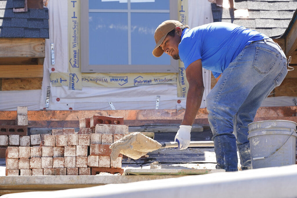 A mason shovels a cement mixture as he prepares to lay down bricks on the exterior wall of a new house in Flowood, Miss. U.S. home construction fell 1.6% in September as builders continue to be tripped up by supply chain bottlenecks.     PHOTO CREDIT: Rogelio V. Solis