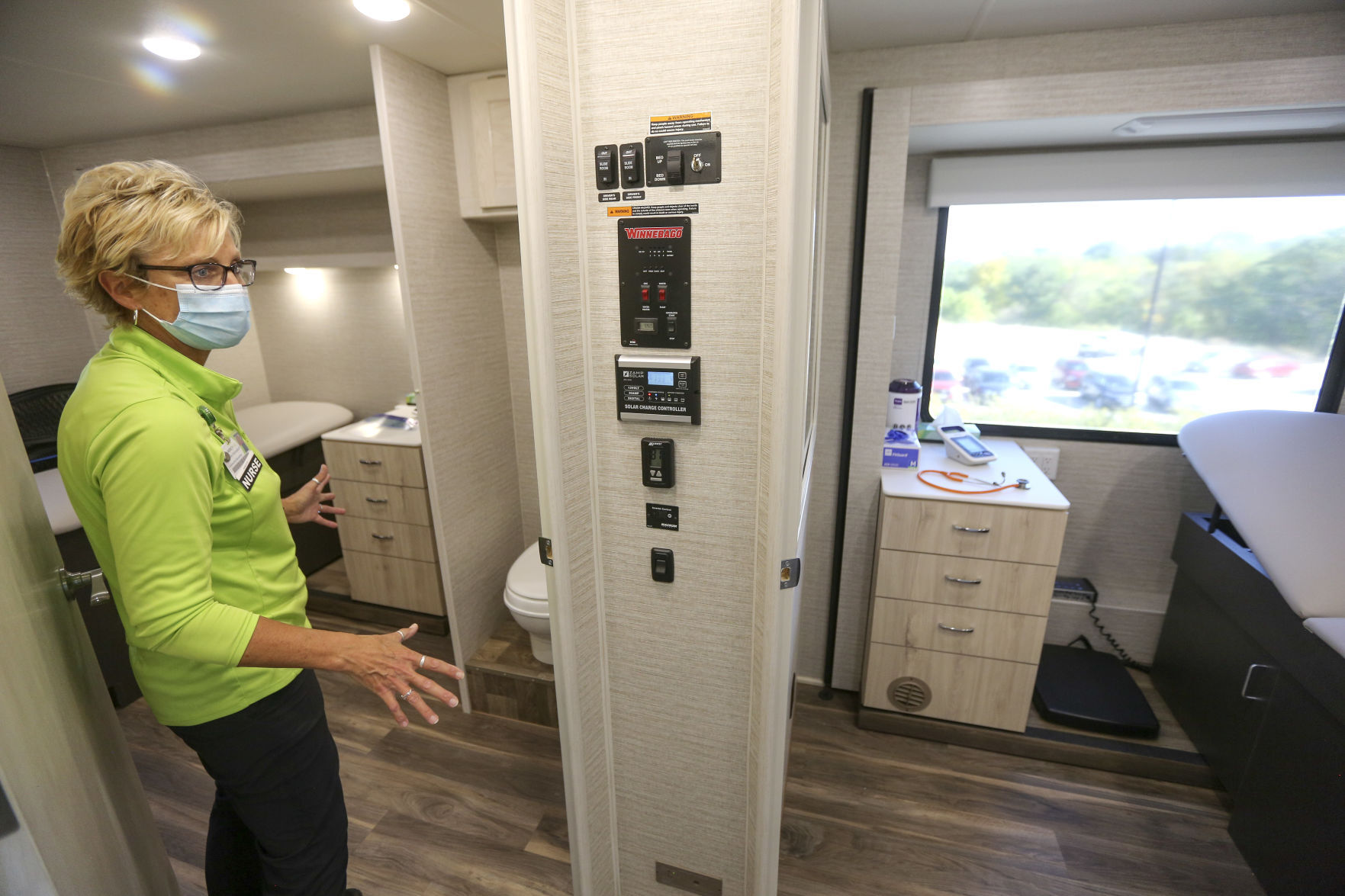 Michelle Arensdorf, MercyOne Dubuque community education and wellness coordinator and a registered nurse, gives a tour of the new mobile medical unit housed within a 31-foot RV on Tuesday. The handicap-accessible mobile medical unit includes two full exam rooms, a waiting area and bathroom.    PHOTO CREDIT: Dave Kettering