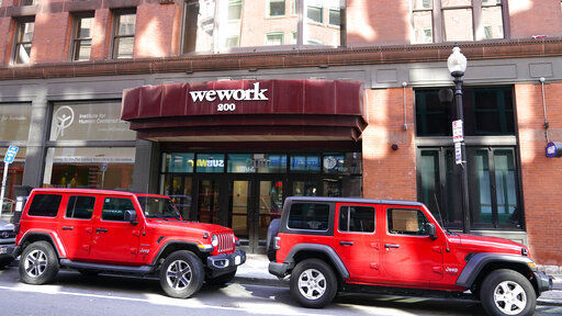 The WeWork logo on the facade of a commercial real estate, shared workspace, Wednesday, July 14, 2021, in Boston. WeWork is set to go public today, its second attempt at a stock offering following a spectacular collapse two years ago.    PHOTO CREDIT: Charles Krupa
