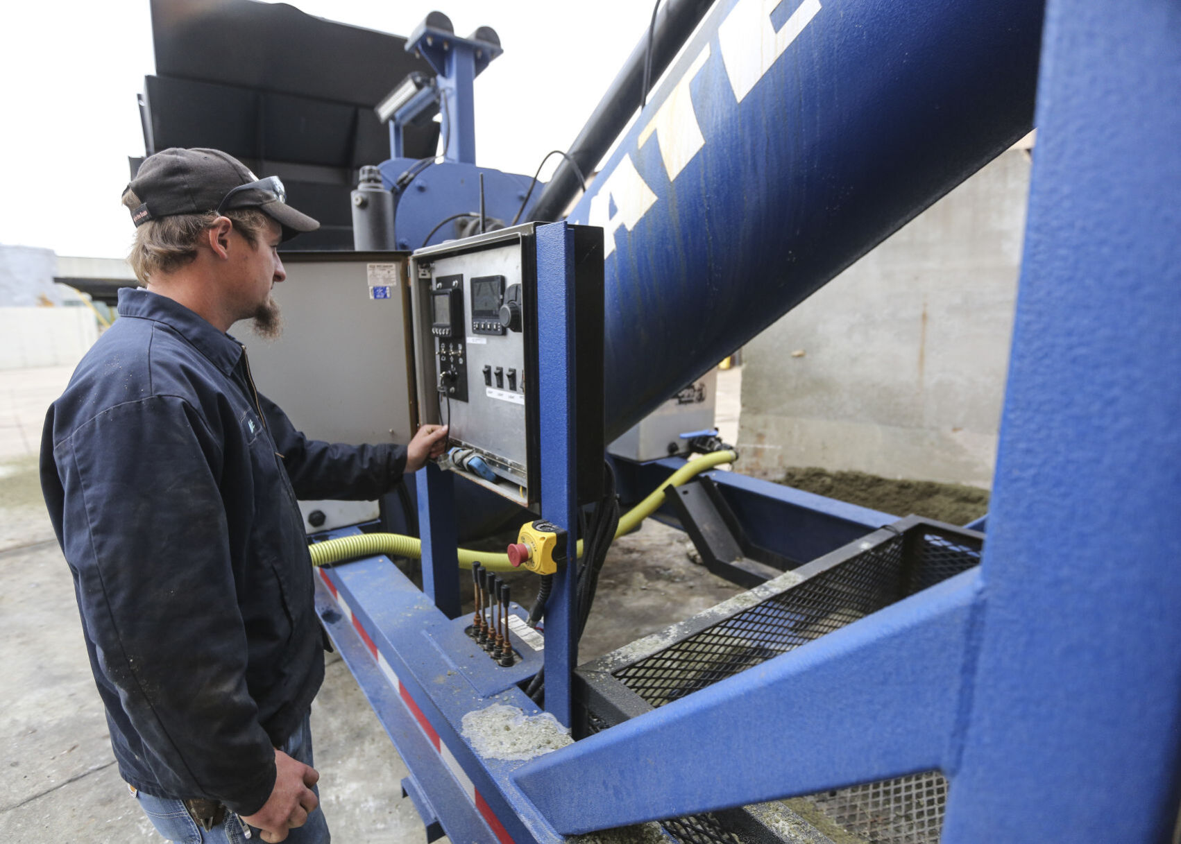 Employee Matt Flynn works with a new piece of equipment that applies liquid treatment to salt at Skyline Salt Solutions in Dubuque on Friday.     PHOTO CREDIT: Dave Kettering