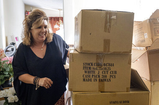 Ginger Pigg moves boxes of shopping bags in the storage room of her gift boutique The Perfect Pigg in Cumming, Ga. on Thursday. The bags should have been delivered in four weeks, but took 14.    PHOTO CREDIT: Ben Gray