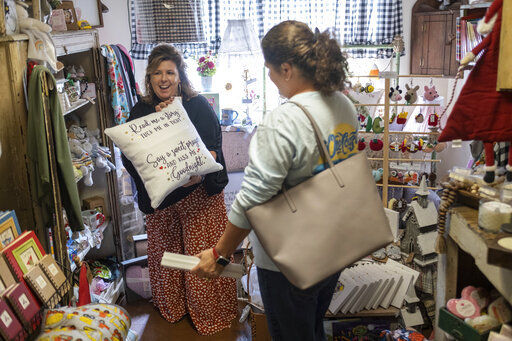 Ginger Pigg suggests a gift to a customer in her gift boutique The Perfect Pigg in Cumming, Ga. on Thursday afternoon, Oct. 22, 2021. She says she is struggling to get products to her store in a timely way. (AP Photo/Ben Gray)    PHOTO CREDIT: Ben Gray