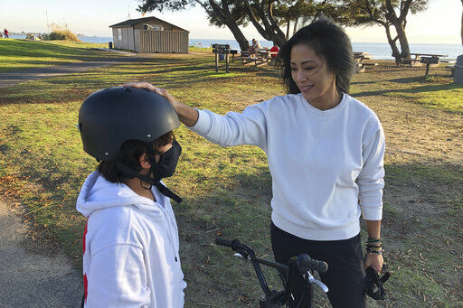 Keryn Francisco interacts with her 10-year-old son Reve Francisco on how to ride a bicycle in Alameda, Calif., on Tuesday, Nov. 2, 2021. As the U.S. economy rebounds from the ongoing pandemic, many women are choosing to sit out the labor force. During her time away from work, Francisco made a discovery that hadn