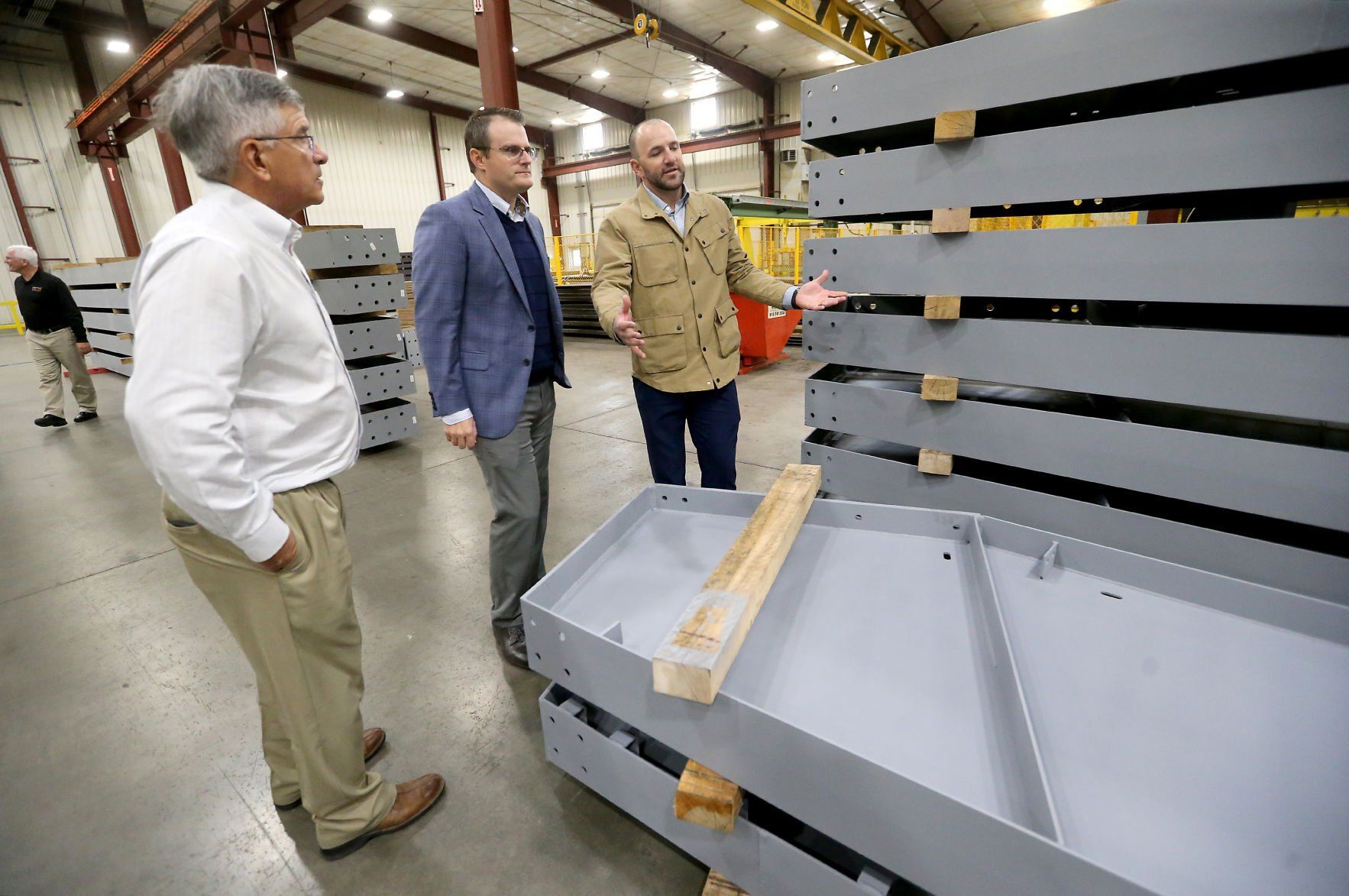 Dave Buchheit (from left), vice president of operations at FarmTek, Iowa Lt. Gov. Adam Gregg and Rob Blush, with FarmTek, talk during a tour of the Dyersville manufacturer Wednesday during an event to unveil its new solar installation.    PHOTO CREDIT: JESSICA REILLY
