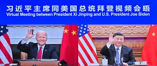 U.S. President Joe Biden and Chinese President Xi Jinping greet one another during their meeting Tuesday via video link.    PHOTO CREDIT: Yue Yuewei